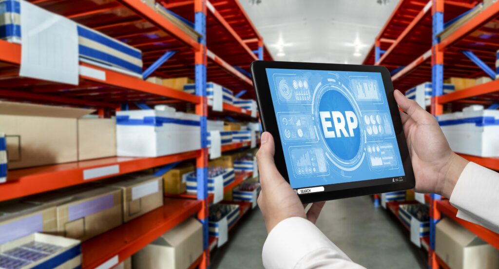pessoa segurando um tablet com a sigla ERP dentro do estoque de uma indústria