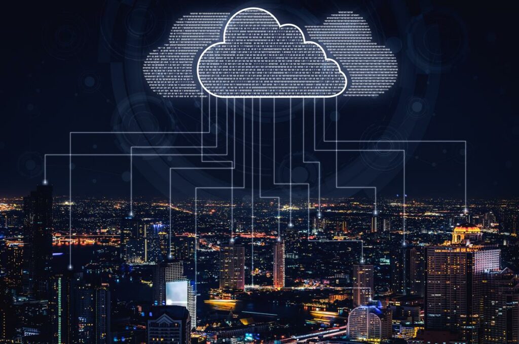 imagem de uma cidade iluminada com uma nuvem em cima enviando dados.