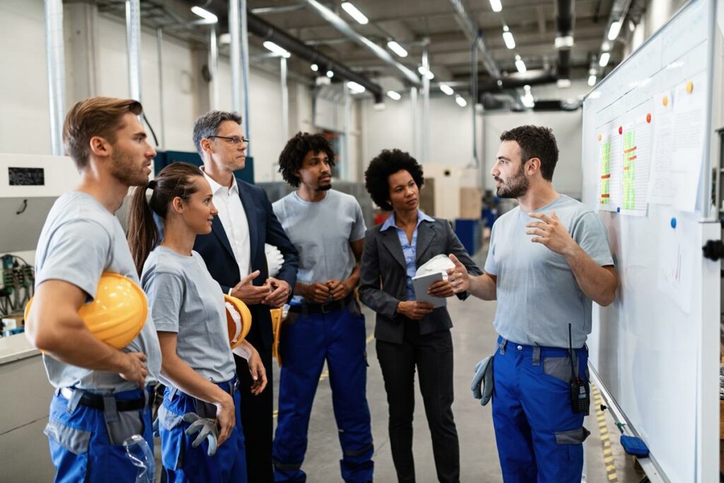 gerente de uma indústria dando treinamento a uma equipe de 5 pessoas.