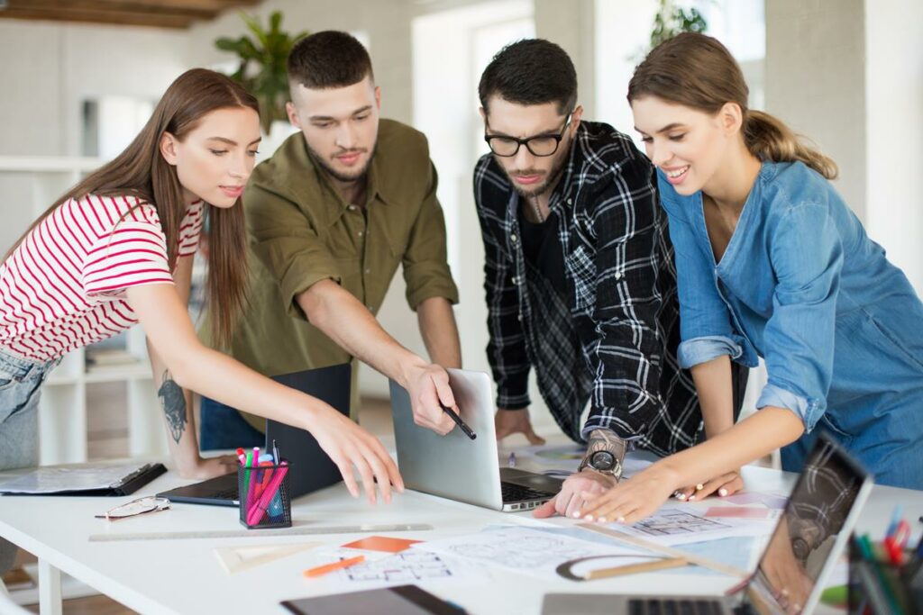 Jovens trabalhando juntos com laptop